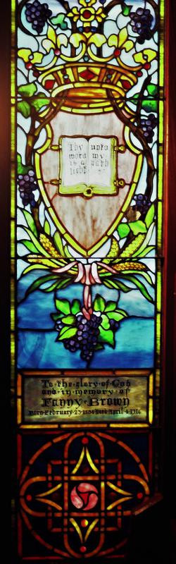 Brown Memorial Window:  a shield containing an open book, surmounted with a jeweled crown, and wrapped in a scrolling grape vine