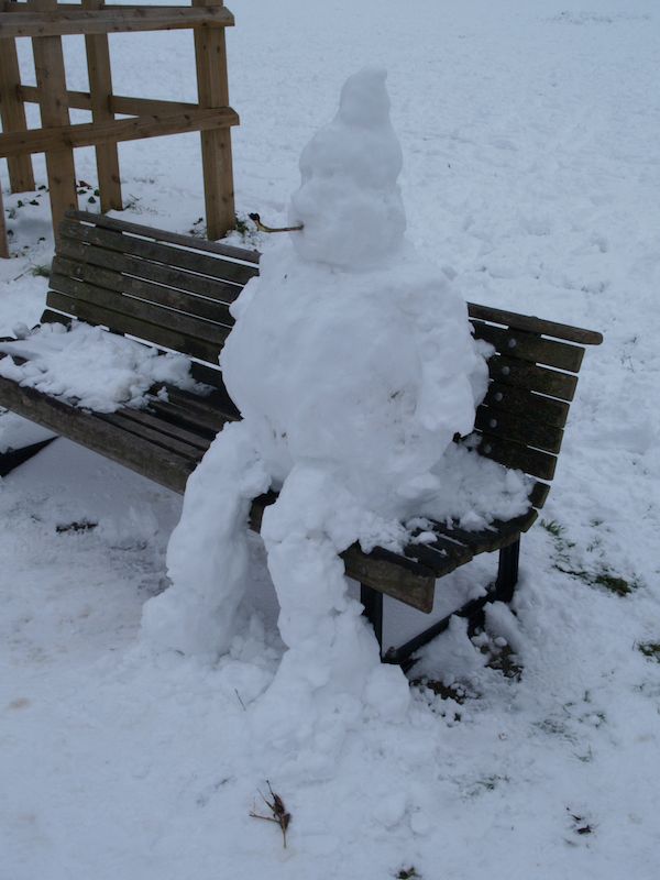 snow man smoking pipe on bench, Midsummer Common, Cambridge, England